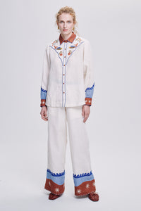 Carolina K rodeo shirt, stylish western-inspired clothing with embroidered details, worn by a model in a casual outdoor setting.
