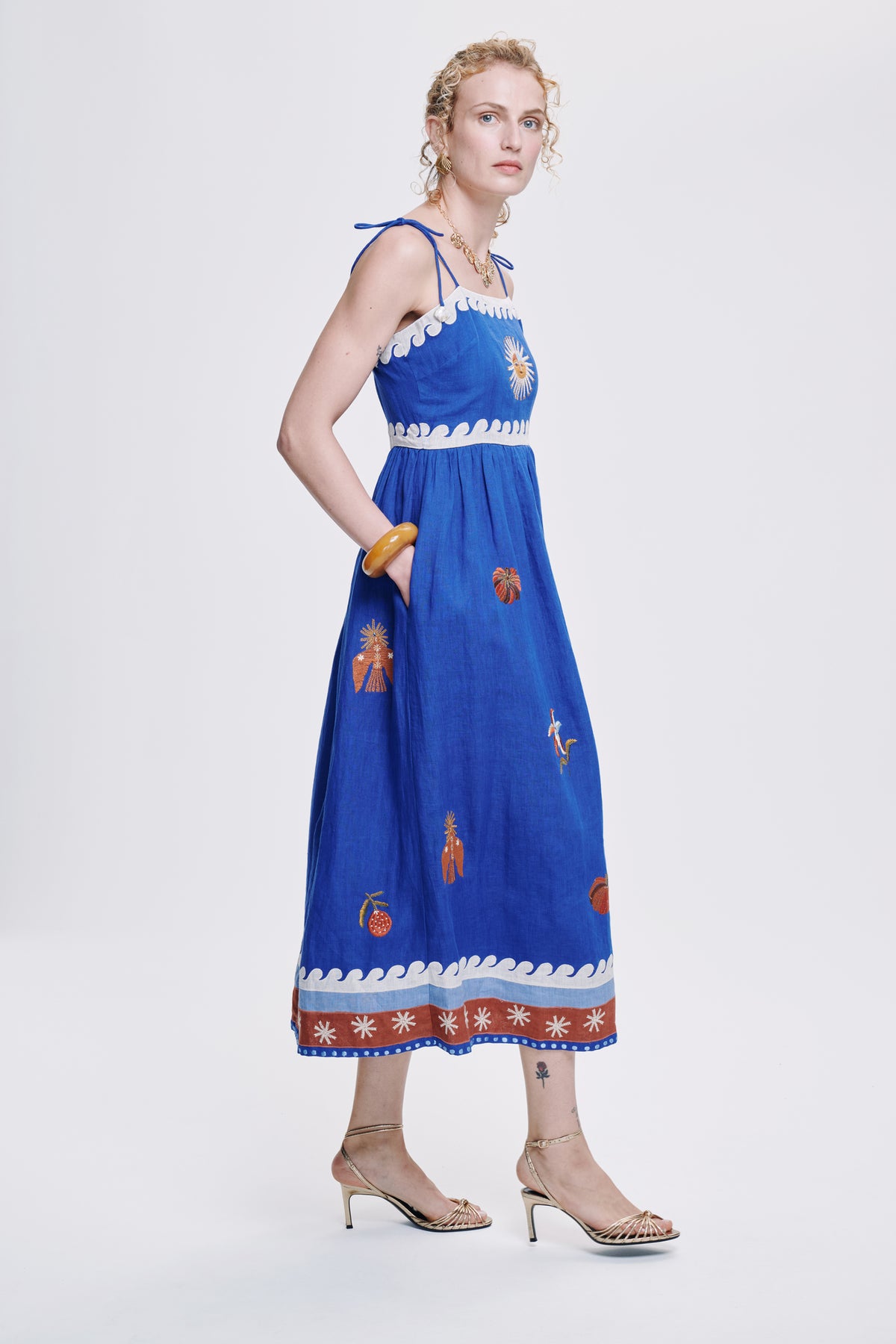 Carolina K Allegra dress in vibrant fabric with flowing silhouette, displayed on a model showcasing elegant women's clothing style.