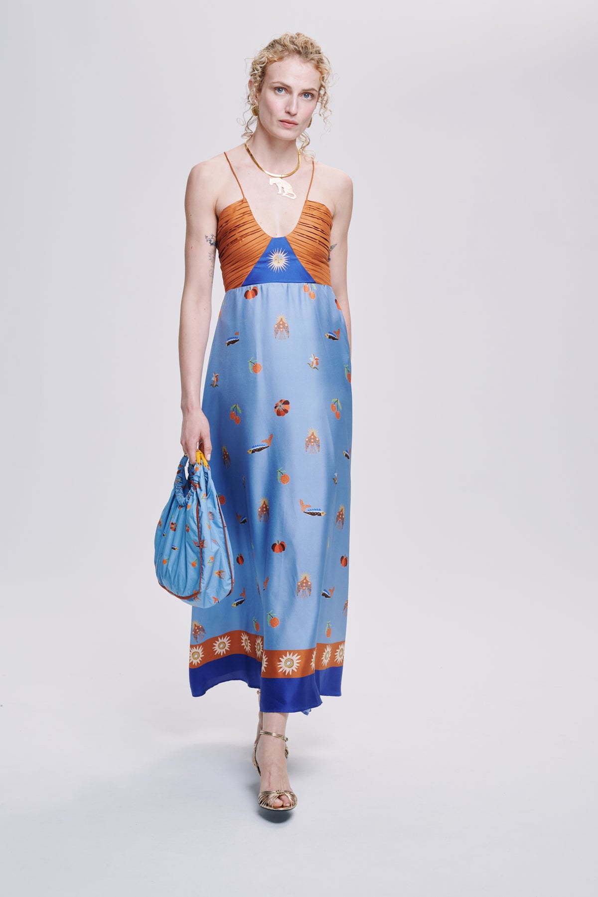 Carolina K Joyce dress in vibrant fabric, flowing silhouette, and intricate patterns, showcased on a model in a stylish setting.