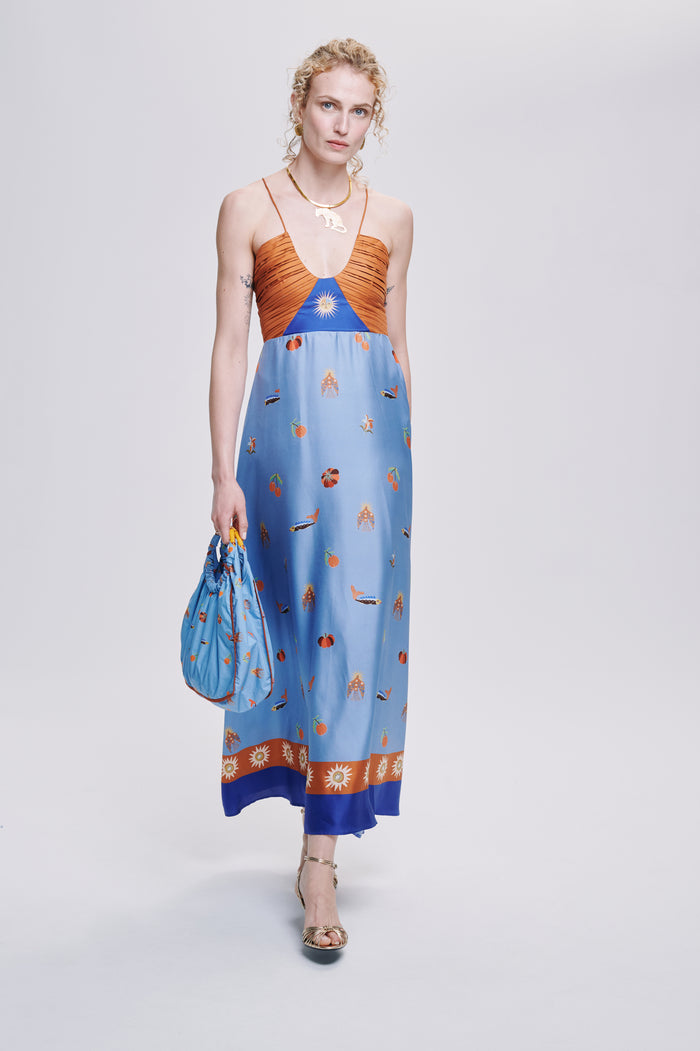 Carolina K Joyce dress in vibrant fabric, flowing silhouette, and intricate patterns, showcased on a model in a stylish setting.