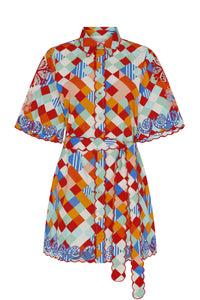 Button-front mini shirt dress in a vibrant multicolor tile print. Designed with a scalloped collar, short sleeves, a removable tie belt, and embroidered accents.