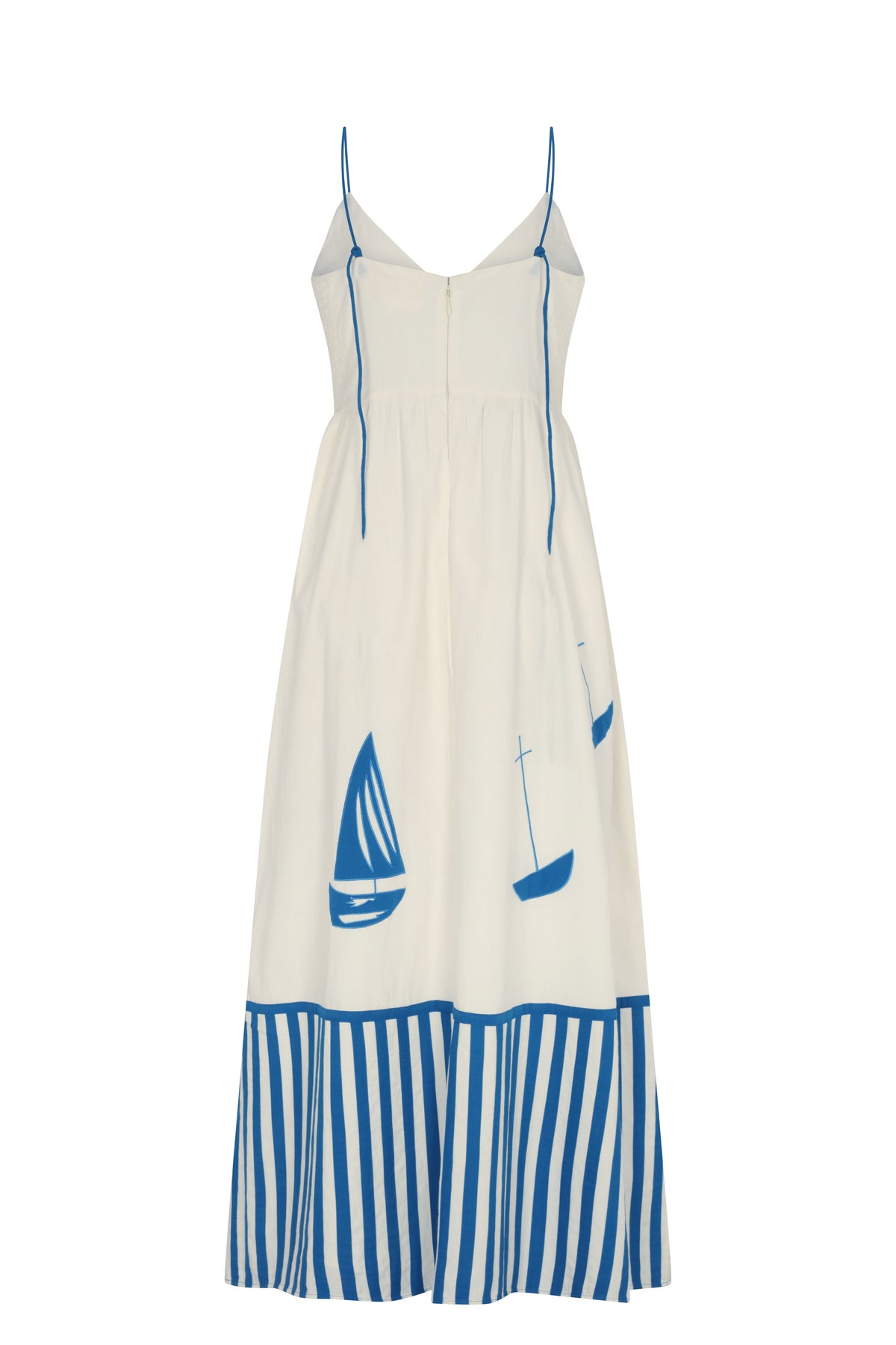 White maxi dress with thin adjustable blue straps, a flowing skirt, and blue sailboat motifs. Features a striped blue-and-white hem and an open V-back design.