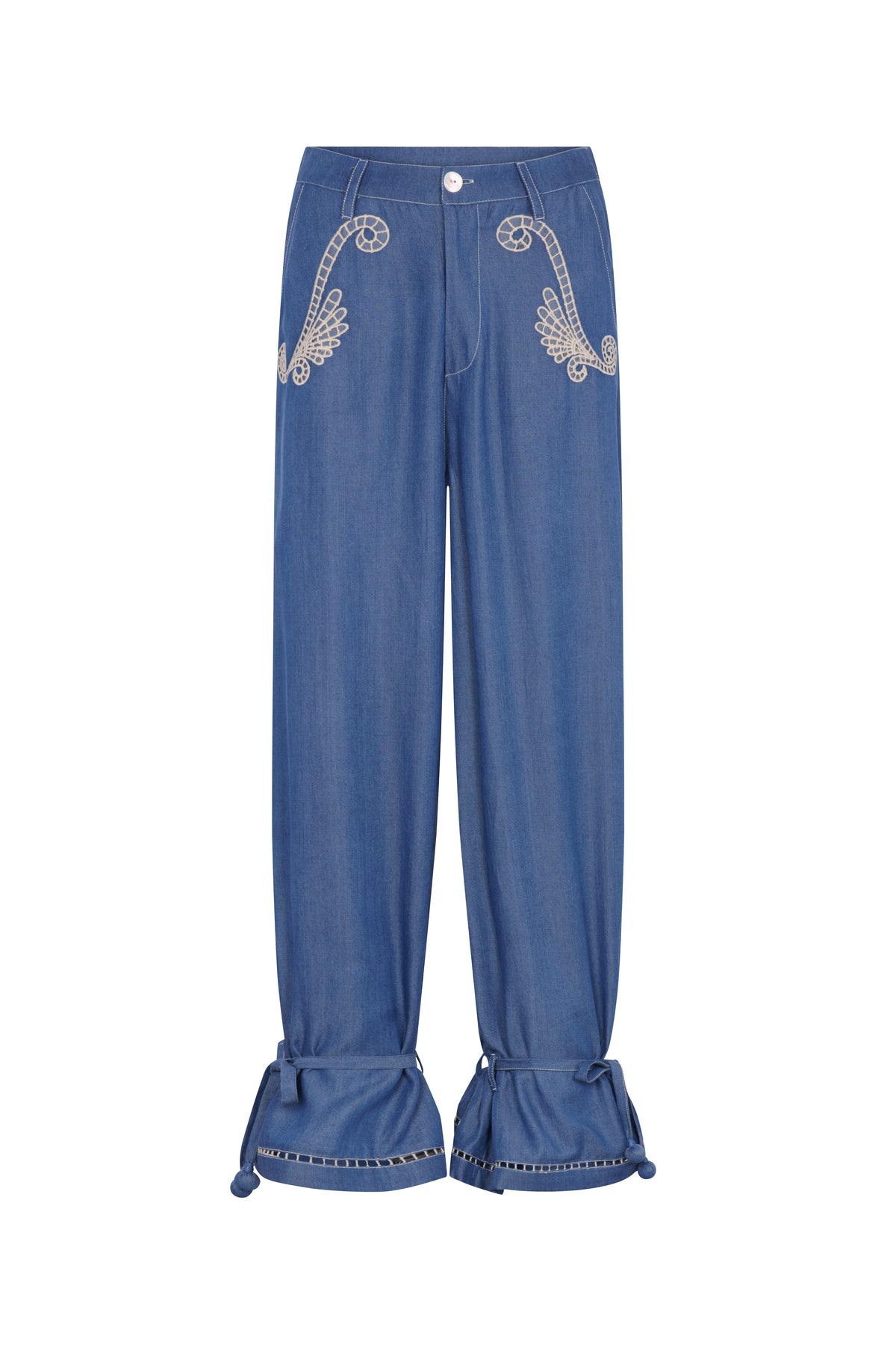 Relaxed-fit denim pants featuring embroidered detailing at the front pockets, a button closure, and adjustable ankle ties with tassel accents. Finished with decorative trim at the cuffs for a handcrafted touch.