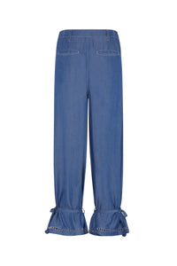 Lightweight denim pants with a relaxed straight-leg silhouette, back welt pockets, and adjustable tie details at the cuffs. Finished with decorative trim and subtle contrast stitching.