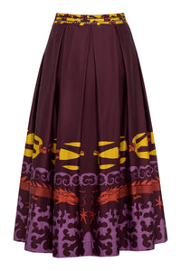 A full, high-waisted A-line skirt in deep maroon featuring a bold multicolor print along the hemline. The print includes stylized yellow human figures, red dragons, and swirling purple motifs, finished with a wide waistband featuring a mix of yellow and maroon patterning.