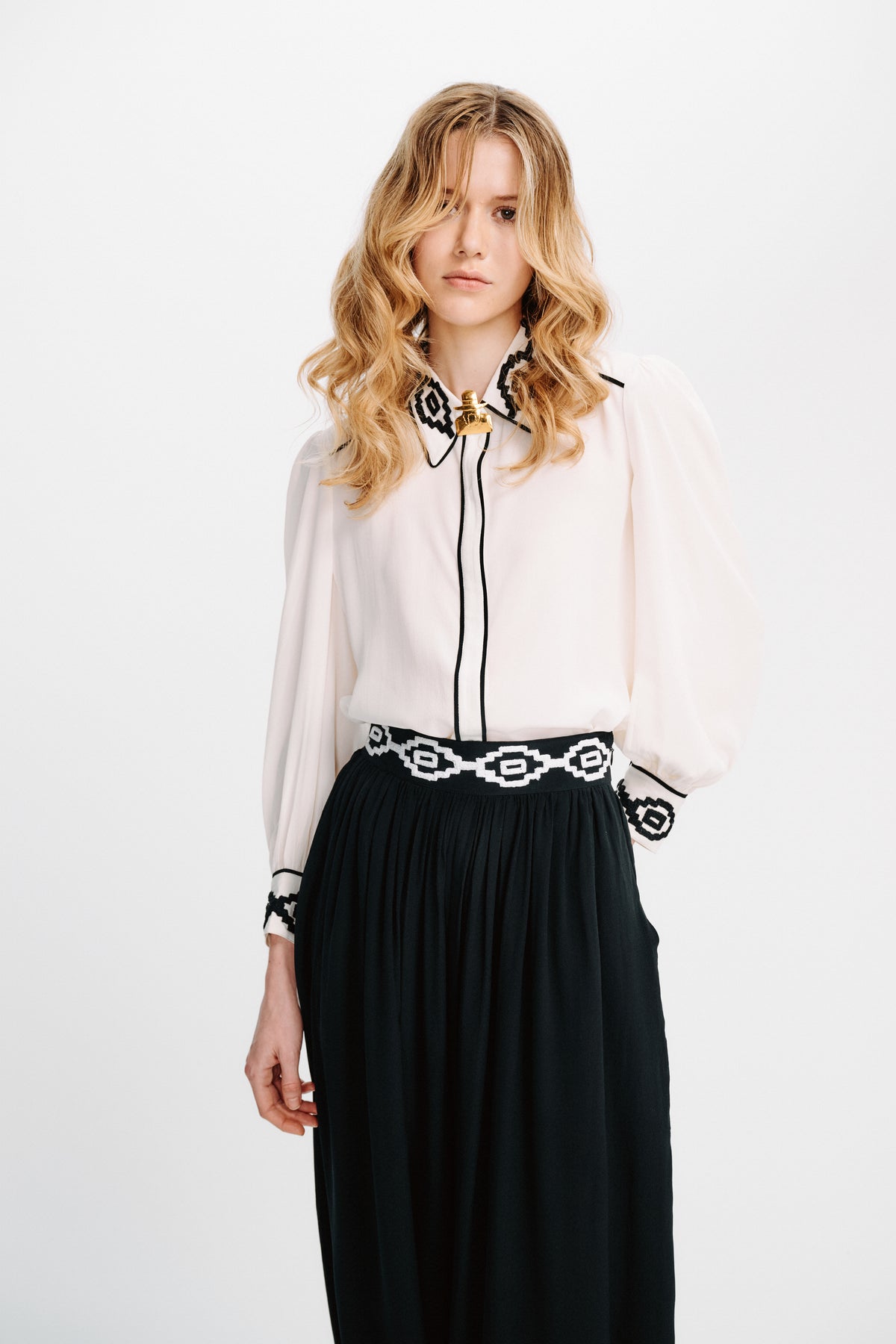 Carolina K Kendall shirt displayed on a hanger, featuring a stylish design with intricate patterns and vibrant colors.
