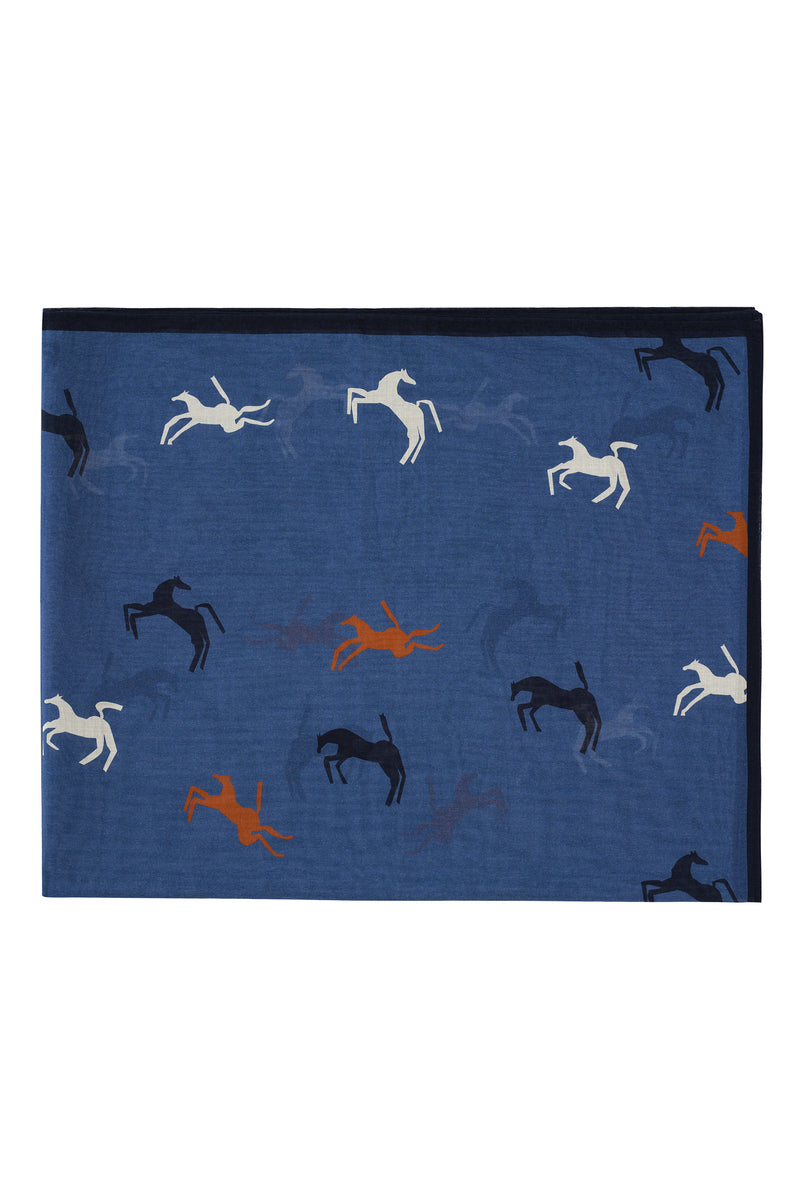 A rectangular blue scarf featuring a playful pattern of stylized horses in motion. The horses are scattered across the surface in shades of white, navy, black, and burnt orange. A slim dark border runs along the top edge, adding a clean finish to the vibrant design.