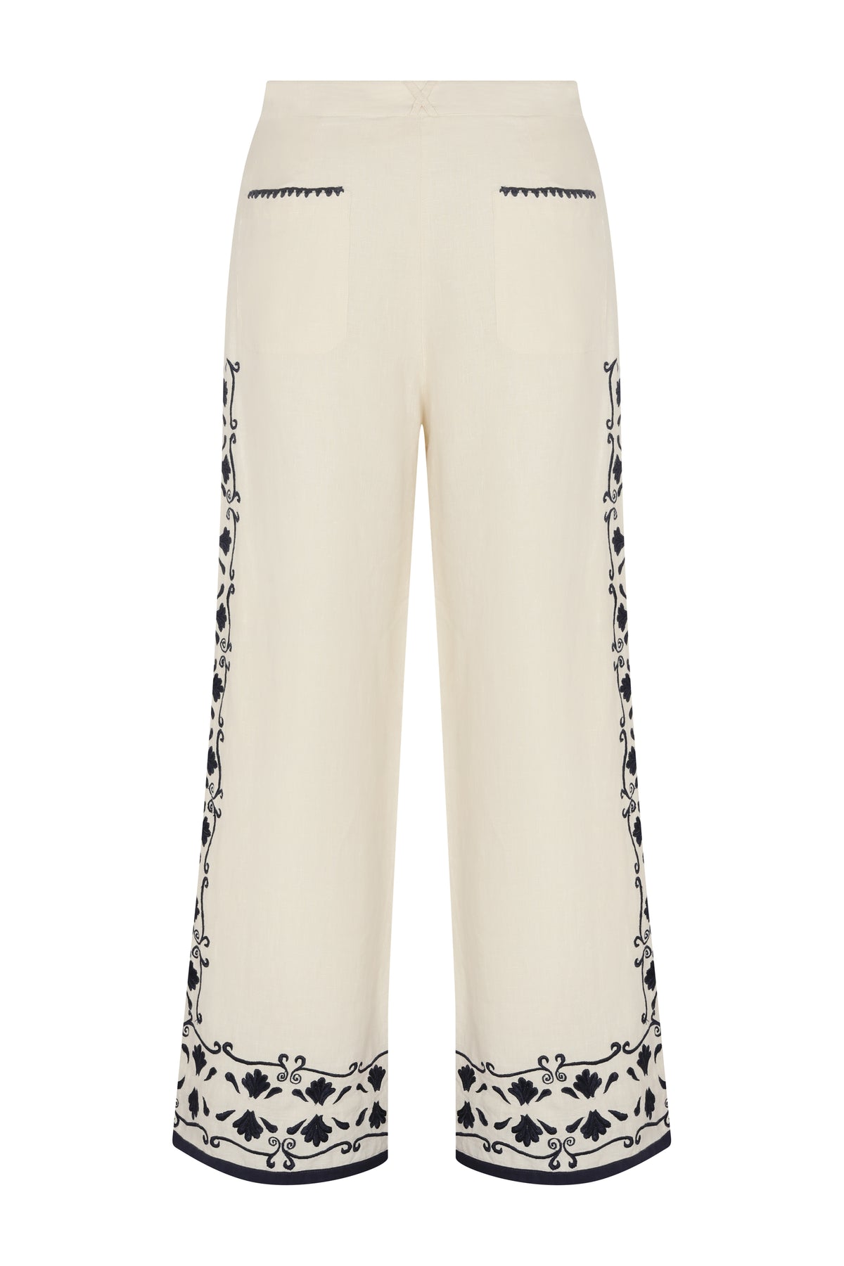 Back view of cream wide-leg pants with navy embroidered trim at the hem and subtle detailing along the back pockets.