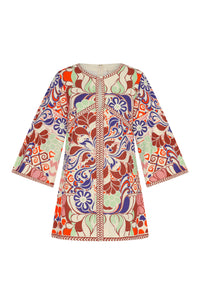 Printed shift dress with a round neckline, wide three-quarter sleeves, and a straight, easy silhouette. The vibrant Punta-inspired pattern combines decorative florals, swirling scrollwork, and geometric elements in rich rust, coral, blue, mint, and cream tones, finished with contrasting patterned trim along the center front and edges.
